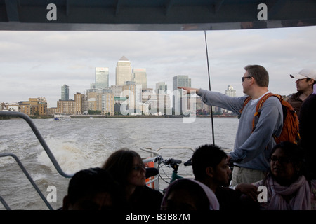 Pfourist Passagiere an Bord Thames Clipper Boot Personenverkehrs auf dem Fluss Themse London Canary Wharf im Hintergrund Stockfoto