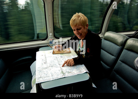 Passagier in Kuppel Auto Beobachtung Trainer Suche nach Standort des Zuges auf Karte Stockfoto