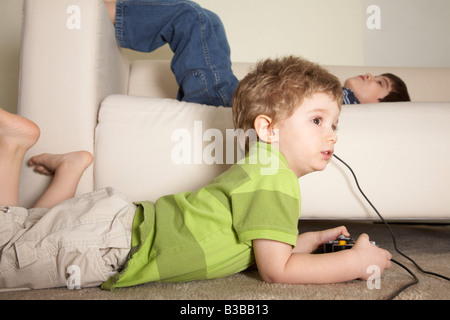 Jungen spielen von Videospielen, Bruder auf Sofa Stockfoto