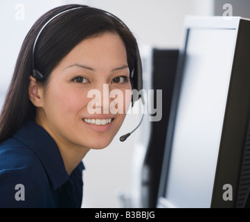 Asiatische Geschäftsfrau trägt Kopfhörer Stockfoto