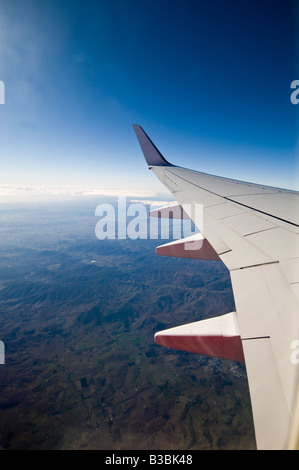 Suchen Sie ein Flugzeug Fenster am Flügel einer Boeing 737-800 bei strahlend blauem Himmel Stockfoto