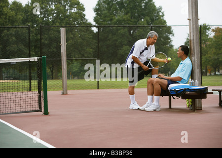 Multi-ethnischen Männer sprechen auf Tennisplatz Stockfoto