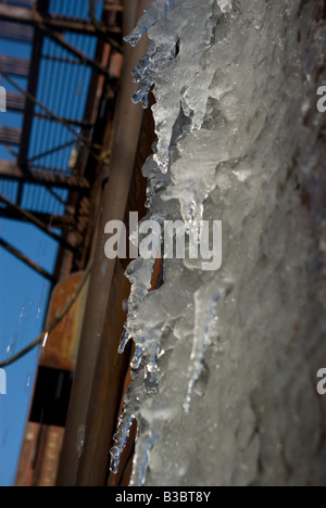 Eiszapfen hängen von der Seite eines Gebäudes nach einem Eissturm Stockfoto