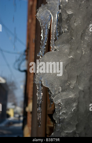 Eiszapfen hängen von der Seite eines Gebäudes nach einem Eissturm Stockfoto