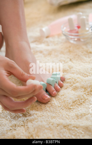 Junge Frau, die Fußnägel Lackieren Stockfoto