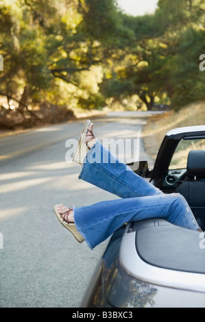 Asiatische Frau die Füße hängen aus Cabrio Stockfoto