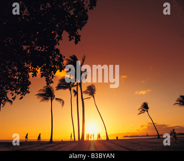 Menschen am Strand bei Sonnenuntergang, Honolulu, Hawaii, Waikiki, USA Stockfoto