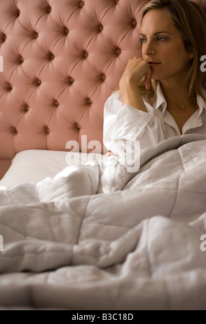 Einer jungen Frau nachdenklich, während Sie im Bett Stockfoto