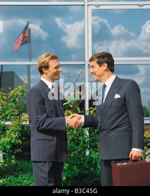 Seitenansicht des Business Männer Handshake vor Bürogebäude Stockfoto