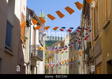 Eine Straße ist für den französischen Nationalfeiertag mit Fahnen und Luftschlangen in Katalanisch und Französisch Farben geschmückt. Stockfoto