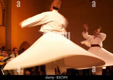 Marokko, Fes. Zwei tanzenden Derwische durchführen während eines Konzerts in der Fes Festival of World Sacred Music. Mitglieder des Al Kindi Ensembles führen die Musik. Stockfoto