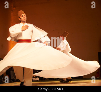 Marokko, Fes. Zwei tanzenden Derwische durchführen während eines Konzerts in der Fes Festival of World Sacred Music. Mitglieder des Al Kindi Ensembles führen die Musik. Stockfoto