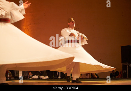 Marokko, Fes. Zwei tanzenden Derwische durchführen während eines Konzerts in der Fes Festival of World Sacred Music. Mitglieder des Al Kindi Ensembles führen die Musik. Stockfoto