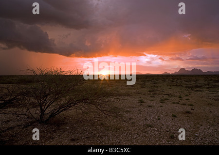 Namibia, Damaraland. Unglaubliche Licht bei stürmischem Wetter über Spitzkoppe Berg "Matterhorn von Afrika" bei Sonnenuntergang. Stockfoto