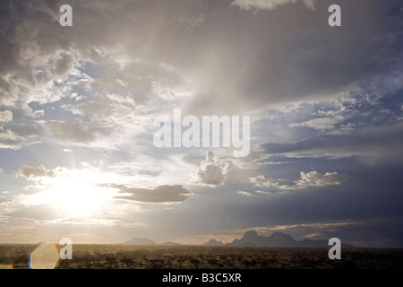 Namibia, Damaraland. Unglaubliche Licht bei stürmischem Wetter über Spitzkoppe Berg am "Matterhorn von Afrika" bei Sonnenuntergang mit Cloud aufbauen und massive Himmel. Stockfoto