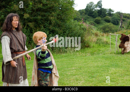 England, Wales, Pembrokeshire. Kinder sind von einer der Führer im Schloss gezeigt, wie man eine Nachahmung Jagd Speer auf ein Ziel zu werfen Stockfoto