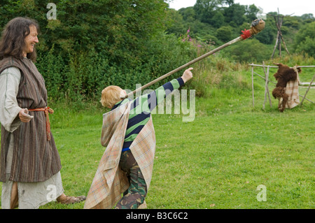 England, Wales, Pembrokeshire. Kinder sind von einer der Führer im Schloss gezeigt, wie man eine Nachahmung Jagd Speer auf ein Ziel zu werfen Stockfoto