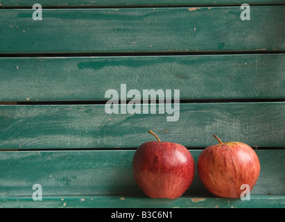 Zwei rote Äpfel im Hintergrund grün Lattenrost aus Holz (Querformat) Stockfoto