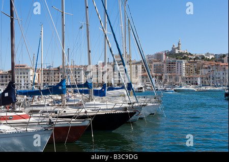 Yachten ankern in der Vieux Port mit der Basilika Notre Dame De La Garde auf dem Hügel hinter Marseille, Cote d ' Azur, Frankreich Stockfoto