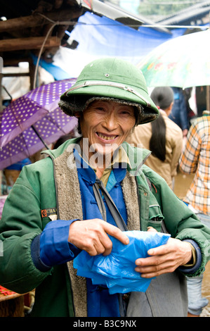 Ein Porträt eines glücklichen Markthändlers, der einen vietnamesischen Armeehut in einem Markt Vietnam trägt Stockfoto