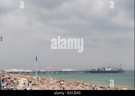 Brighton Beach an einem sonnigen Tag mit weitgehend bewölktem Himmel mit Menschen gefüllt. Stockfoto