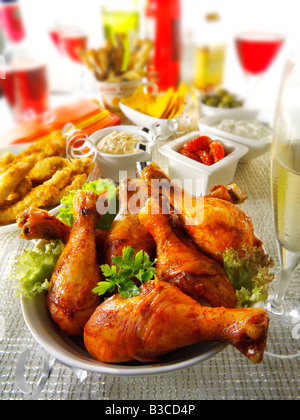 Party Essen Einstellung mit Chicken Drumsticks, Goujons und Sonne getrockneten Tomaten-dip Stockfoto