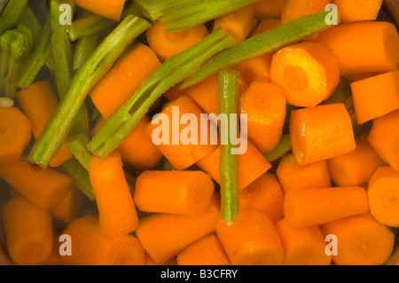 Nahaufnahme von Karotten und Stangenbohnen in den Topf mit Wasser zum Kochen bereit. Stockfoto