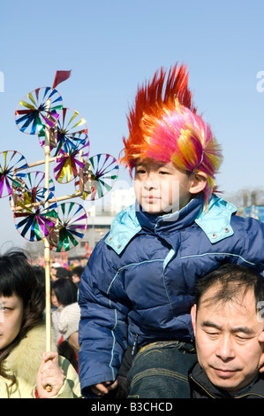 China, Peking. Chinesische neue Jahr Frühlingsfest - Changdian Straßenfest - ein Mann, der sein Kind mit einem Wind Vane Spielzeug trägt. Stockfoto