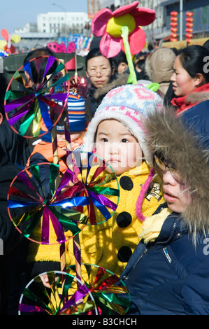 China, Peking. Chinesische neue Jahr Frühlingsfest - Changdian Straßenfest - ein Mann, der sein Kind mit einem Wind Vane Spielzeug trägt Stockfoto