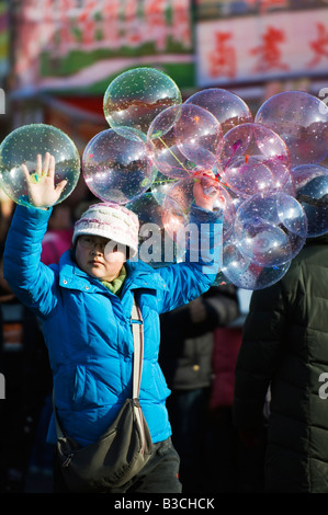 China, Peking. Chinese New Jahr Frühlingsfest - ein Mädchen Ballons an der Changdian Street fair zu verkaufen. Stockfoto