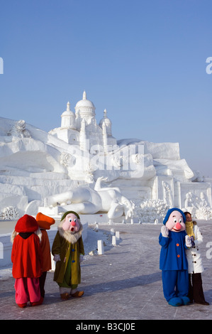 China, Nordost-China, Provinz Heilongjiang Harbin City. Schnee und Eis Schneeskulpturen-Festival im Sun Island Park. Die sieben Zwerge posiert für Fotos vor riesigen Schnee Skulpturen. Stockfoto