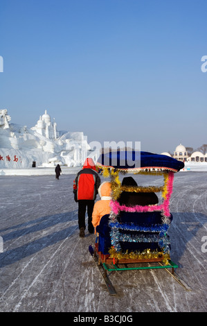 China, Nordost-China, Provinz Heilongjiang Harbin City. Hundeschlitten fahren auf Schnee und Eis Schneeskulpturen-Festival im Sun Island Park. Stockfoto