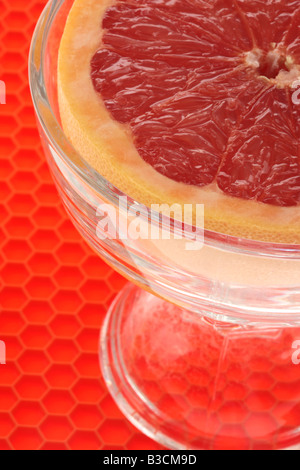 Frische reife Saftig eine halbe Frühstück Grapefruit In einer Schüssel mit keine Menschen auf rotem Hintergrund Stockfoto