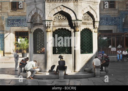 Anbeter vorbereiten, beten im Innenhof Yeni Camii (neue Moschee), Istanbul, Türkei Stockfoto