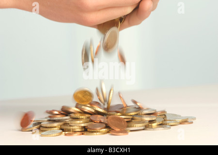 Münzen fallen aus Händen Stockfoto