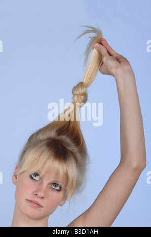 Junge Frau hält ihr Haar, Porträt Stockfoto