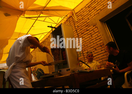 Usbekische Mann Vorbereitung Shawarma in einer Chaikhana, einem orientalischen Teehaus auf dem Großmarkt in Urgentsch, Usbekistan Stockfoto