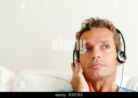 ein Mann hört Musik durch seine Kopfhörer Stockfoto