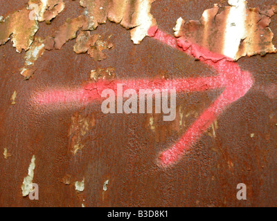 Rot lackierte Pfeil auf einem rostigen Metall Hintergrund Stockfoto