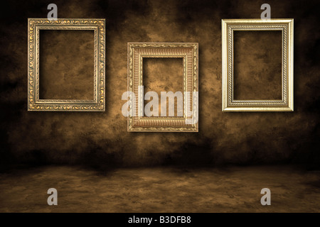 Drei vergoldeten Bilderrahmen an einer Grunge Wand hängen Stockfoto