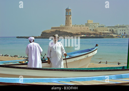 Zwei Männer tragen traditionelle Kleidung mit Angelboote/Fischerboote Sur Sharqiya Region Sultanat von Oman Stockfoto