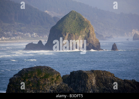 Sunrise und Meer-Stacks auf dem Strand in Cannon Oregon mit einem dramatischen Himmel im Hintergrund Stockfoto
