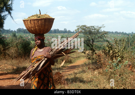 Frau mit Korb und Brennholz in Uganda. Stockfoto