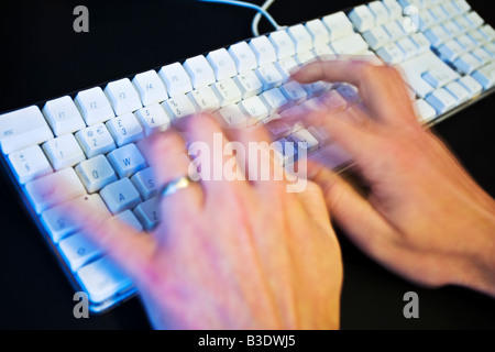 Männliche Hände auf einer Computertastatur tippen Stockfoto