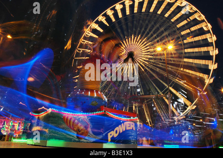 bunte Messegelände fahren mit Riesenrad in der Abenddämmerung Stockfoto