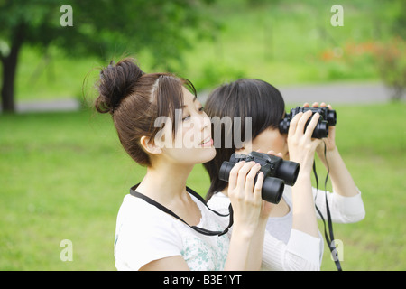 Junge Frauen auf der Suche durch ein Fernglas Stockfoto