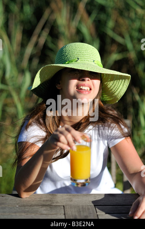 Frau trinkt ihr frischen gepresster Orangensaft zum Frühstück im Süden von Frankreich. Stockfoto