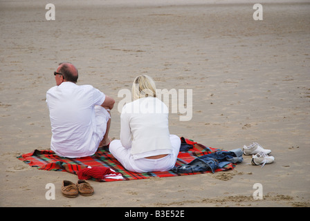 Älteres Paar am Strand sitzen Stockfoto