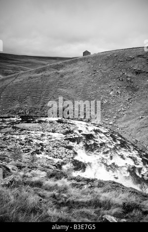 Der River Tees in Flut fließt vorbei an einer abgelegenen Scheune im oberen Teesdale Stockfoto