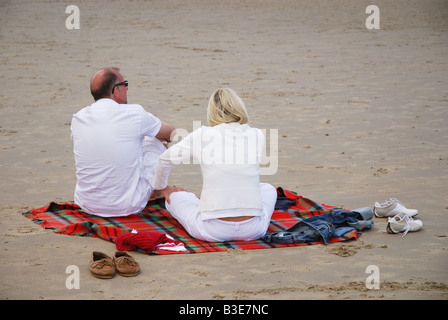 Älteres Paar am Strand sitzen Stockfoto